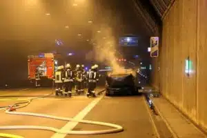 Einsatzkräfte in einem Tunnel. Im Hintergrund Löschwasser.