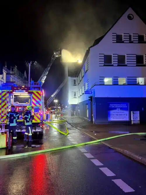 Einsatzfahrzeuge vor dem vom Wohnungsbrand betroffenen Haus