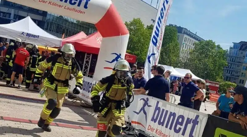 Mit ihrer gesamten Ausrüstung laufen die Einsatzkräfte für den Verein km4kids beim Kölnturm Treppenlauf.