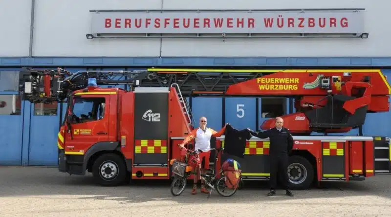 Brandoberinspektor Christoph Hartmann (rechts) überreicht Jörg Richter ein Poloshirt, dass ihn an seine Radtour vom Mittelmeer über die Alpen nach München erinnern soll.