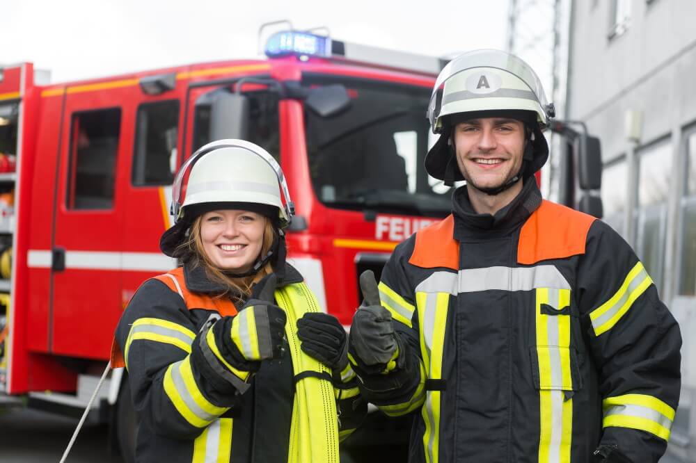 Schlauch in den Händen. weiblicher feuerwehrmann in schutzuniform