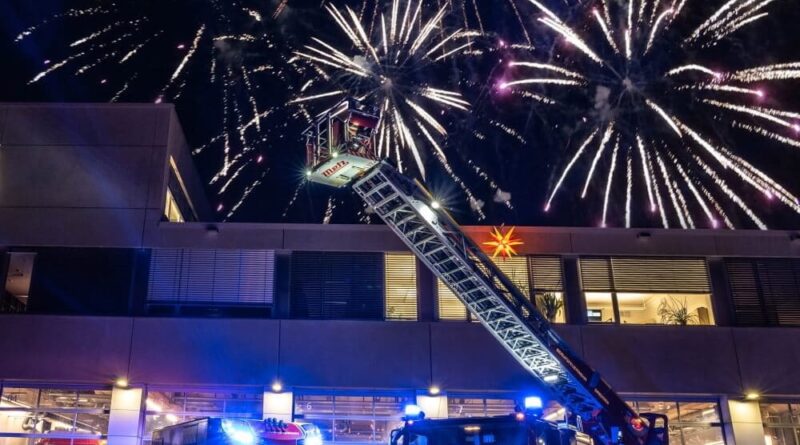 Zwei Feuerwehrautos begrüßen unter einem Feuerwerk das neue Jahr. Doch leider war die Silvesternacht 2021/22 für viele Feuerwehren einsatzreich.