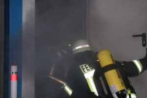 Eine Einsatzkraft mit Atemschutz in einem vernebelten Raum.