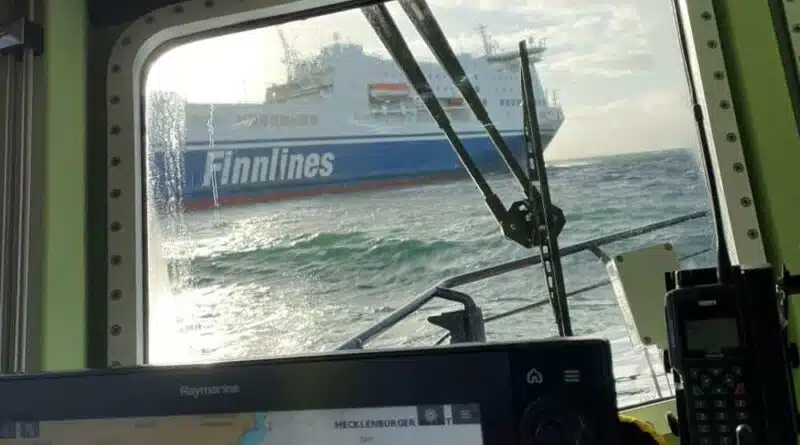 Sie sehen durch ein Bootsfenster ein Schiff der Seenotrettung.