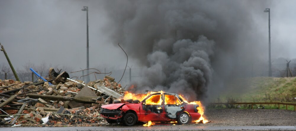 Das Bild zeigt ein brennendes Auto in der Ukraine.