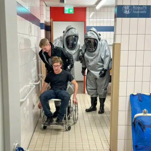 Verletztendarsteller wird auf dem Rollstuhl nach draußen gebracht