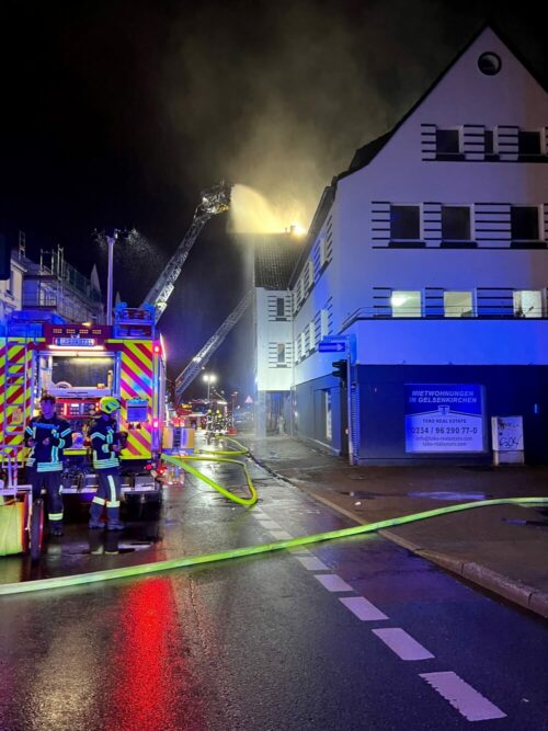 Einsatzfahrzeuge vor dem vom Wohnungsbrand betroffenen Haus 