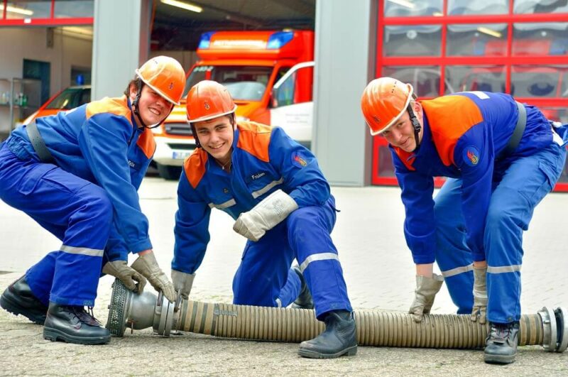 Drei Angehörige der Jugendfeuerwehr beim Kuppeln einer Saugleitung (Symbolbild).