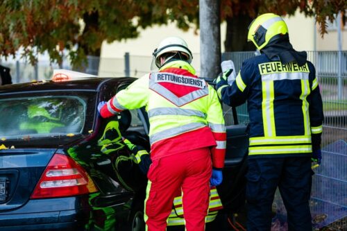 Mitarbeiter von Feurewehr und Rettungsdienst an einem Unfallfahrzeug (Symbolbild).