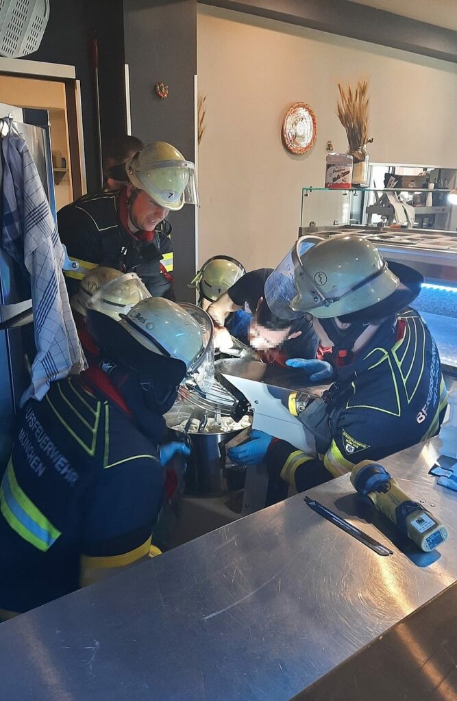 Pizzabäcker mit Hand in Teigknetmaschine