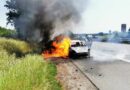 Lagebild: Brennnendes Auto und Böschungsbrand am Fahrbahnrand der A1.