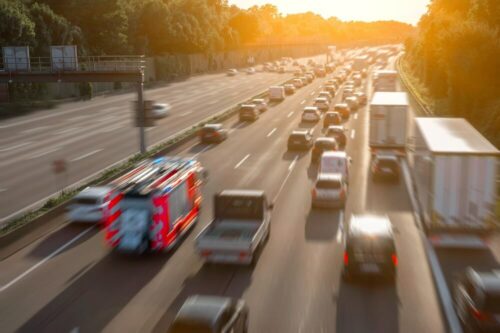 Rettungsgasse auf einer Autobahn mit EInsatzfahrzeug, das sein Wegerecht nutzt.