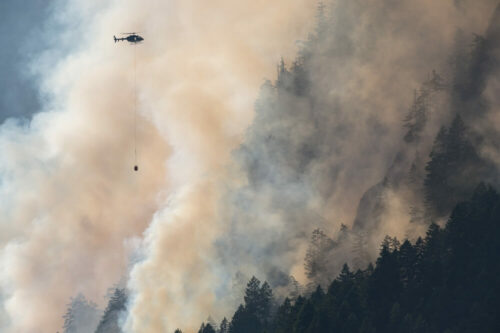Mit Helikoptern kämpfen die Einsatzkräfte gegen die anhaltenden Flammen. Riesige Rauchwolken ziehen auf.