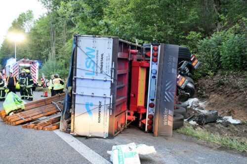 Einsatzkräfte vor dem umgekippten Lkw