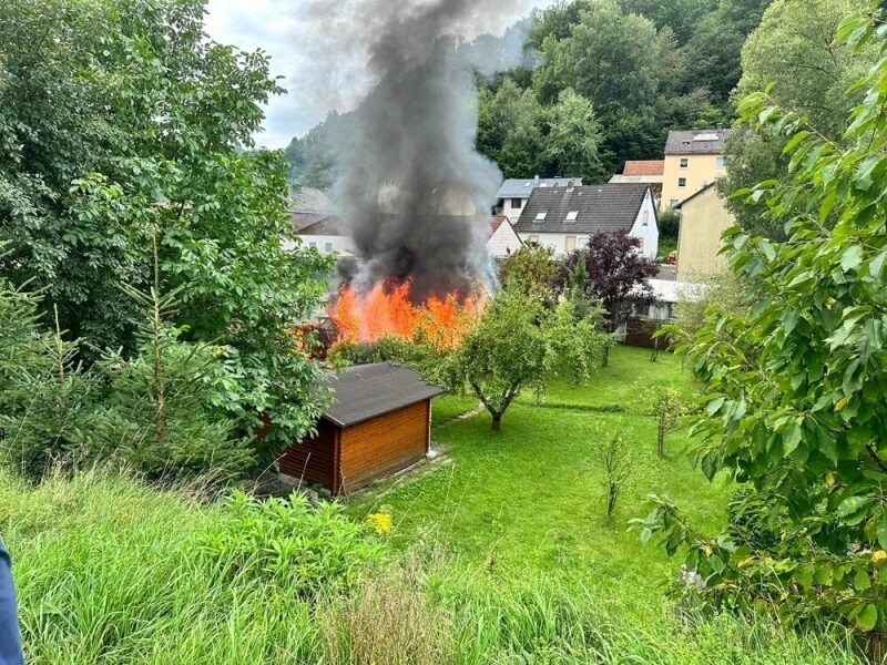 Flammen und Rauchschwaden schlagen aus dem Gartenhaus.
