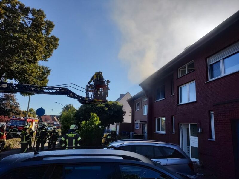 Aus dem Fenster der Brandwohnung in dem Mehrfamilienhaus steigt Rauch auf.