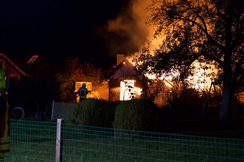 Feuerwehrmann löscht die Flammen im Schrebergarten