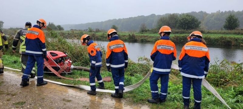 Mitglieder der Jugendfeuerwehr Alveslohe verbinden Schläuche für den Weltrekord.