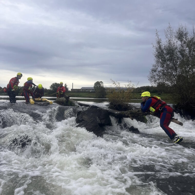 Ein reißender Fluss mit Einheiten der Strömungsrettung.