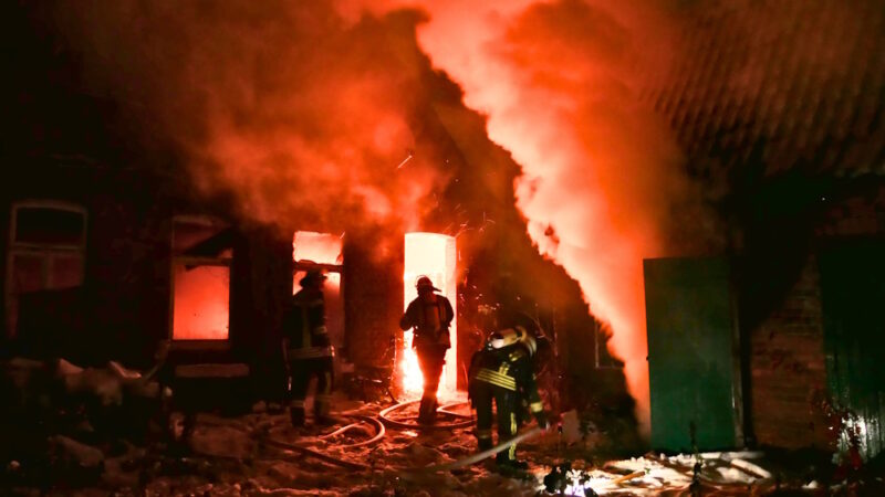 Einsatzkräfte löschen den schweren Brand in einem Gebäude.