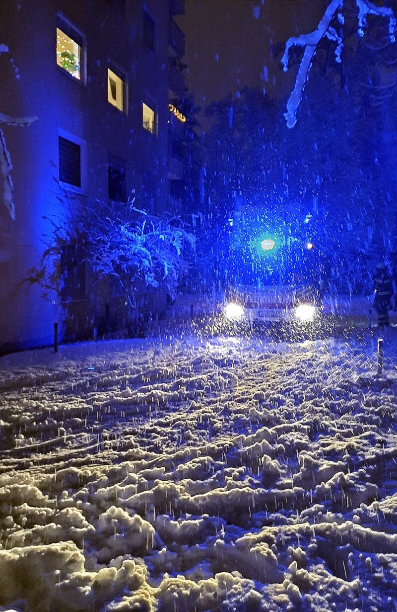 Wintereinbruch in München. Feuerwehrwagen im Hintergrund.