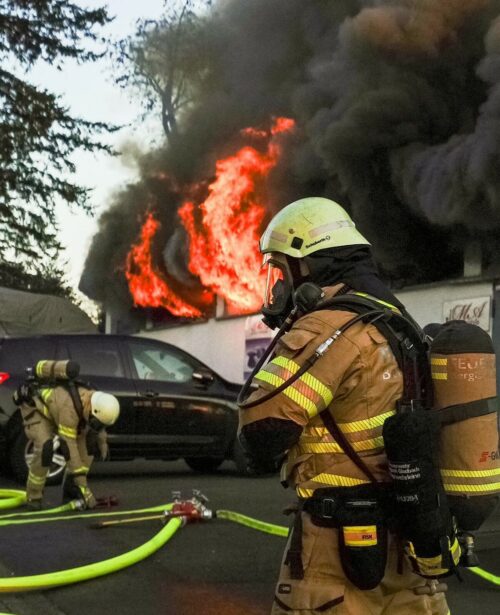 Flammen schlagen aus dem Fenster der Gewerbehalle. 