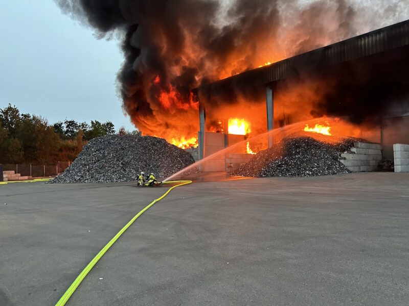 Feuerkräfte löschen einen Brand in einem Recyclingbetrieb