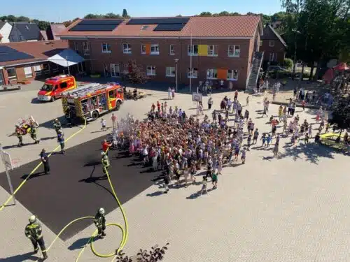 Abkühlung gefällig? Die FF Werne brachte Spaß in die Evakuierungsübung und erfrischte die Schüler/-innen nach Zählung und Feststellung der Vollständigkeit. Foto: FF Werne.