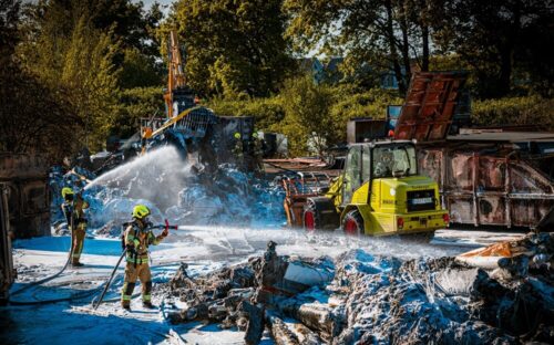 Während der Löscharbeiten zogen Bagger die abgelöschten Kunststoffreste aus den Containern. Foto: Feuerwehr Gronau